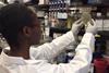 Scientist examines COVID-19 vaccine agar plate