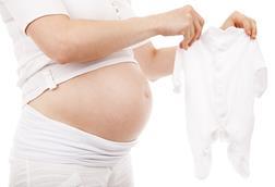 Pregnant_woman_holds_white_babygrow_sleeper