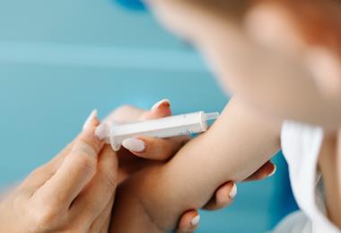 Child_receiving_a_vaccination_in_a_healthcare_setting_with_a_medical_professional_present