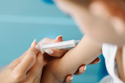 Child_receiving_a_vaccination_in_a_healthcare_setting_with_a_medical_professional_present
