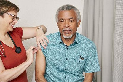 Older_man_about_to_receive_a_vaccine_from_a_doctor_(48545999642)