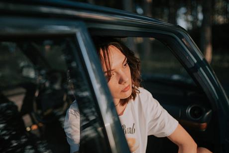 Depressed_woman_resting_in_car_during_golden_hour_near_forest