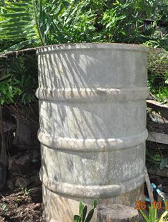 Household water storage tank. Note missing lid and open mesh cover