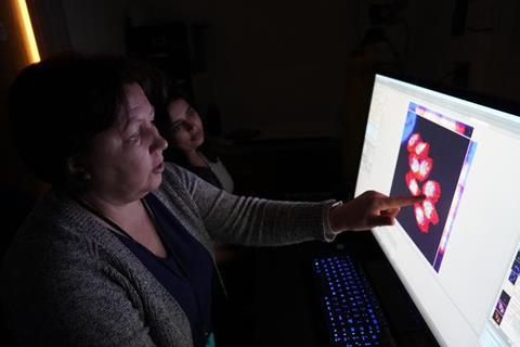 Low-Res_Elena Suvorova and Mrinalini Batra observing the detailed toxomplasma cells -- credit USF