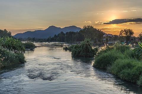 Sunset on the Mekong banks showing the river and hills beyond